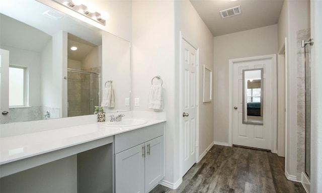 bathroom featuring an enclosed shower, vanity, wood-type flooring, and plenty of natural light