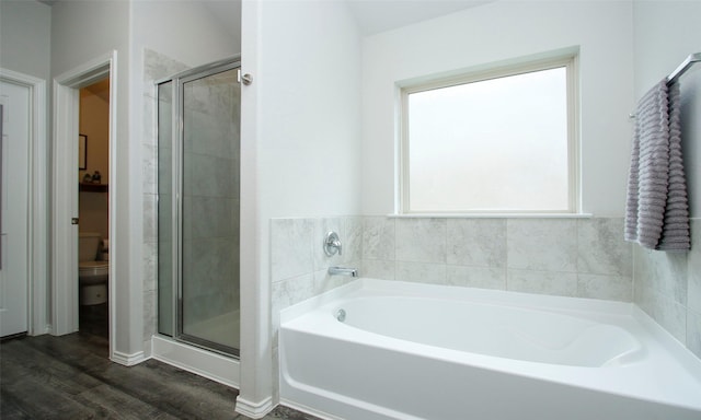 bathroom with wood-type flooring, toilet, and separate shower and tub