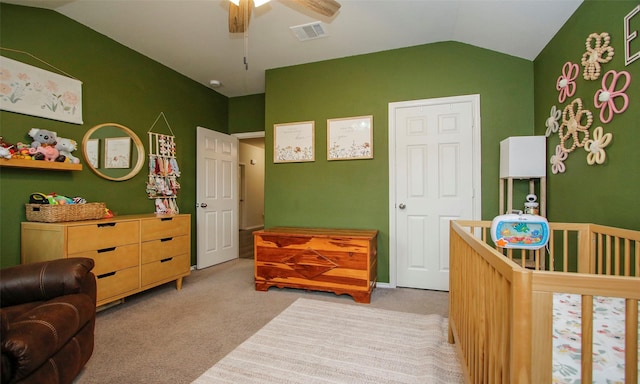 bedroom featuring ceiling fan, carpet, a nursery area, and lofted ceiling