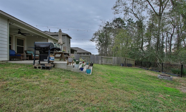 view of yard featuring ceiling fan and a patio