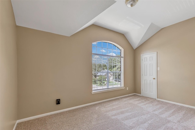 unfurnished room with lofted ceiling and light carpet