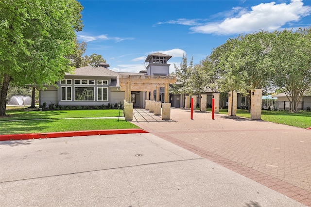 view of front of house with a front yard and a pergola