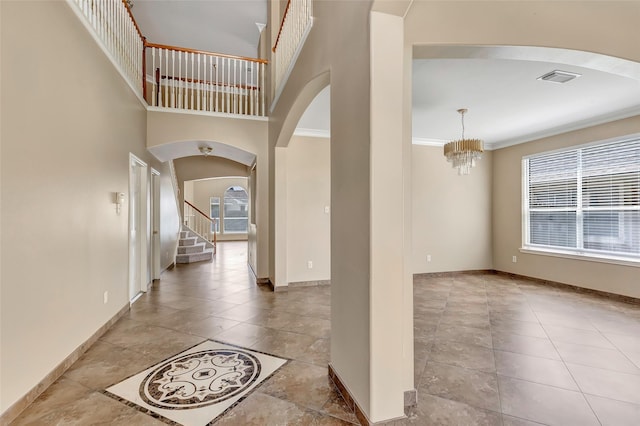 entrance foyer featuring crown molding and an inviting chandelier