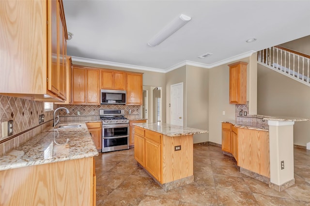 kitchen with light stone counters, sink, a center island, and stainless steel appliances