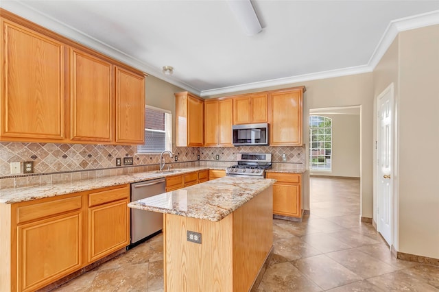 kitchen with a center island, sink, crown molding, light stone countertops, and appliances with stainless steel finishes