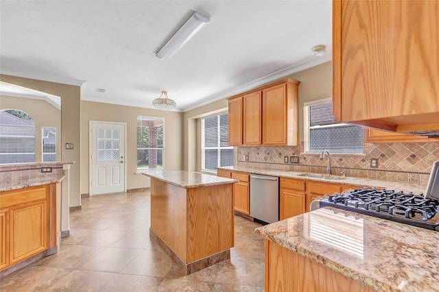 kitchen with tasteful backsplash, a kitchen island, stainless steel dishwasher, sink, and light stone counters