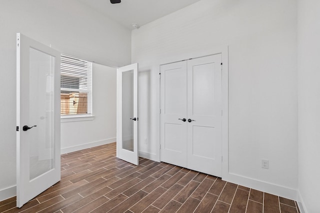 21514 Witham Promenade Ln, Magnolia, TX 77355 - unfurnished bedroom featuring a closet, dark wood-style flooring, french doors, and baseboards