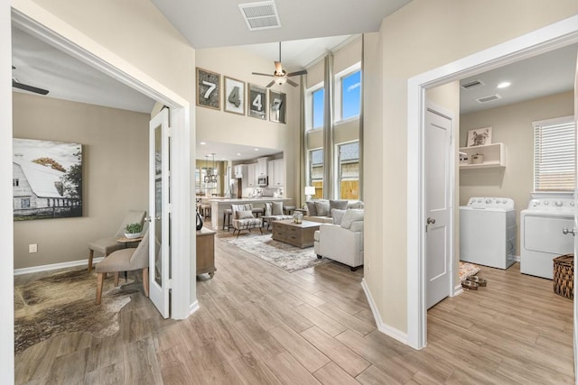 interior space featuring light hardwood / wood-style floors, ceiling fan, and independent washer and dryer