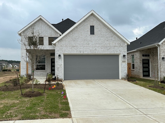 view of front of home with concrete driveway, an attached garage, and brick siding