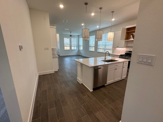 kitchen featuring tasteful backsplash, wood tiled floor, white cabinets, stainless steel appliances, and a sink