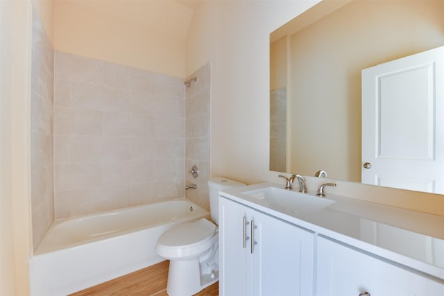 full bathroom featuring toilet, tiled shower / bath, vanity, and hardwood / wood-style floors