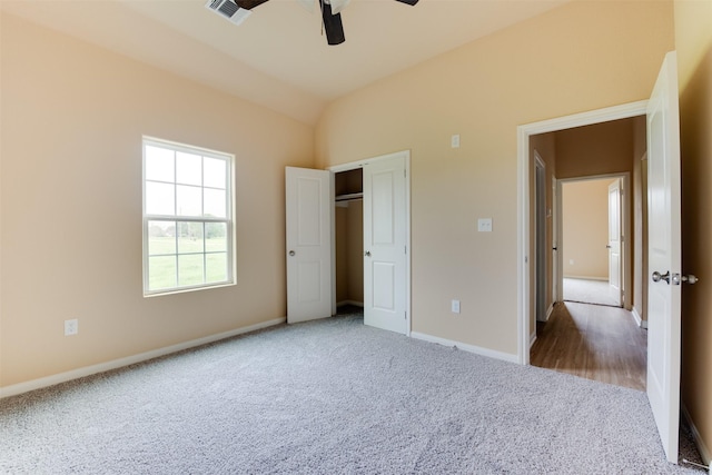 unfurnished bedroom featuring ceiling fan, carpet, lofted ceiling, and a closet