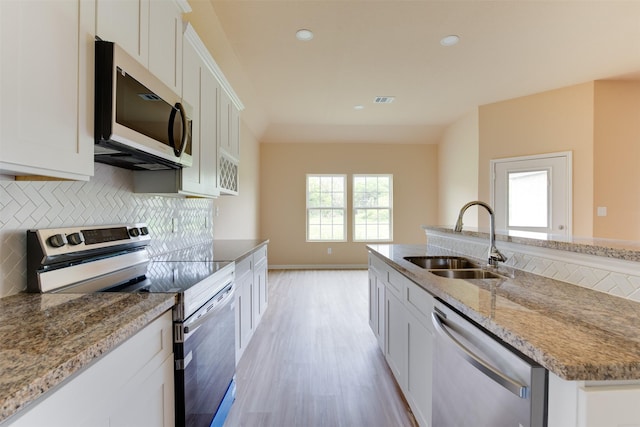 kitchen featuring light stone counters, sink, white cabinetry, and appliances with stainless steel finishes