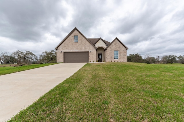 view of front facade featuring driveway, a garage, a front lawn, and brick siding