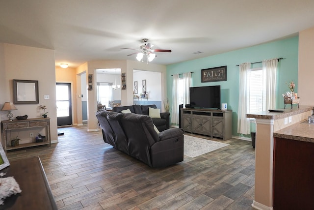 living room with ceiling fan, plenty of natural light, and dark hardwood / wood-style floors