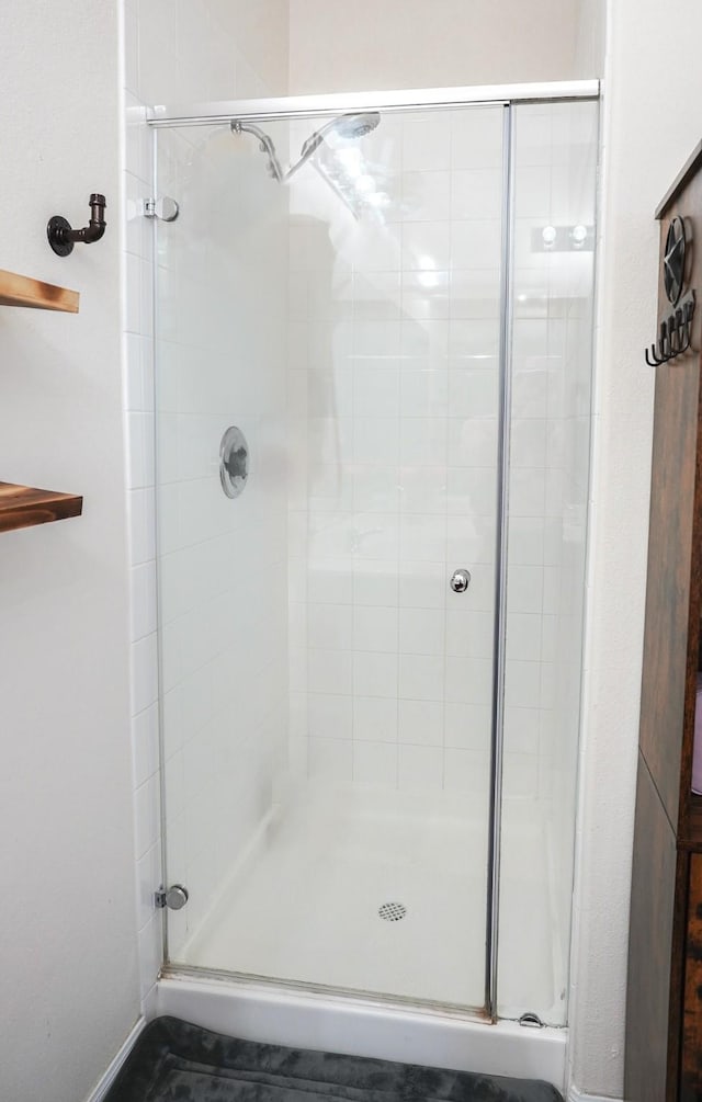 bathroom featuring a shower with shower door