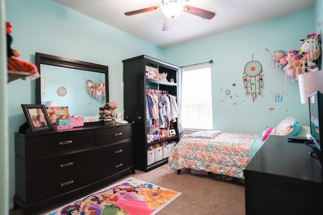 bedroom featuring ceiling fan, a closet, and light colored carpet