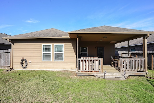 rear view of property with a yard and a wooden deck