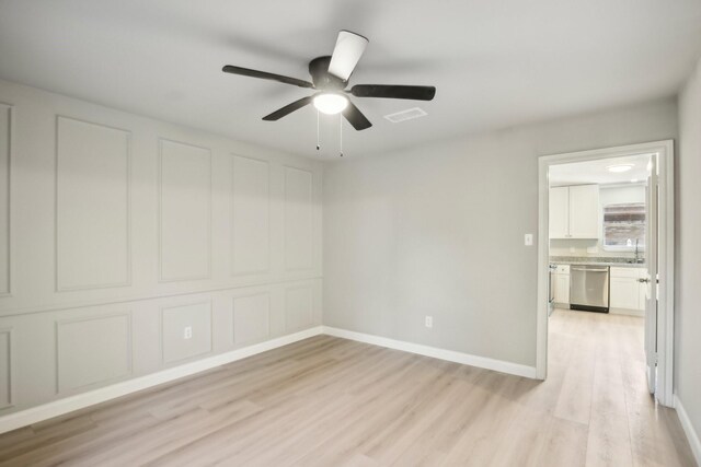 spare room featuring ceiling fan, light wood-type flooring, and sink