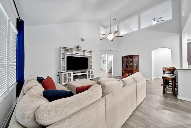 living room featuring ceiling fan, light hardwood / wood-style floors, and high vaulted ceiling