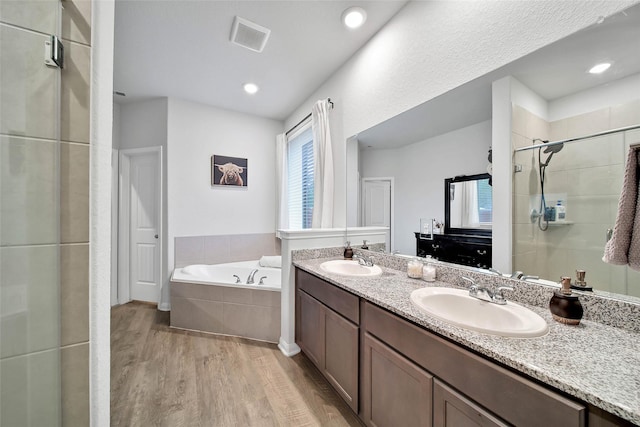 bathroom featuring vanity, independent shower and bath, and hardwood / wood-style floors