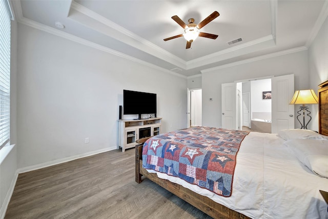 bedroom with ceiling fan, crown molding, a tray ceiling, and connected bathroom