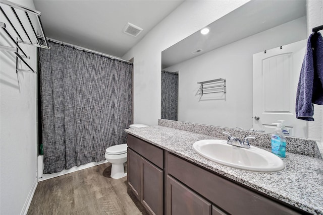 full bathroom featuring wood-type flooring, toilet, vanity, and shower / bathtub combination with curtain