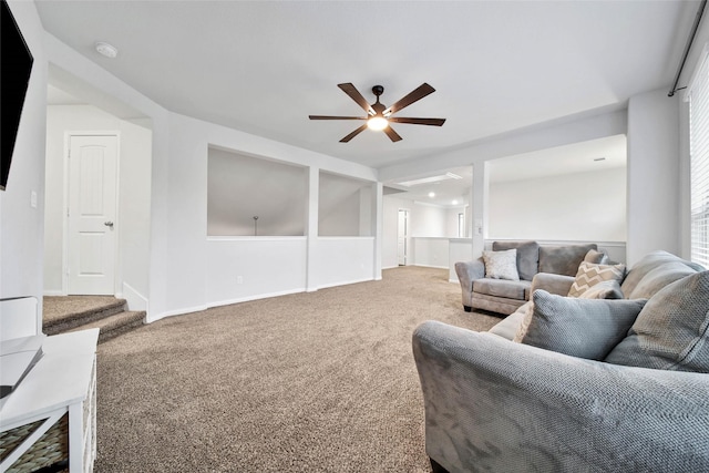 carpeted living room with ceiling fan