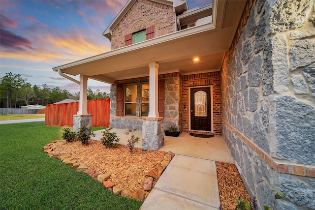 exterior entry at dusk with a lawn and a porch