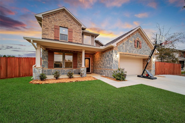 view of front of home with covered porch, a garage, and a yard