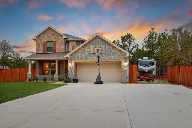 view of front of home with a porch, a yard, and a garage