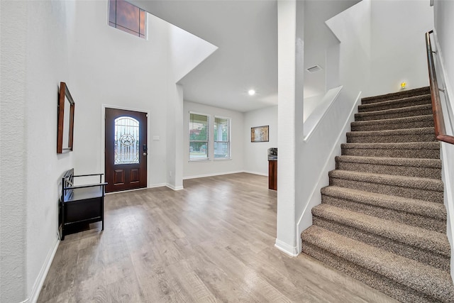 entrance foyer with a high ceiling and light hardwood / wood-style floors