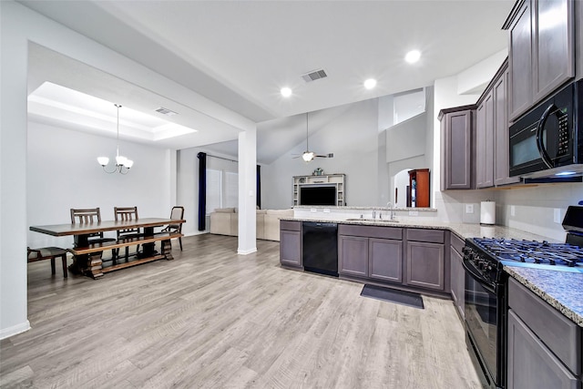 kitchen featuring black appliances, decorative light fixtures, sink, and light wood-type flooring