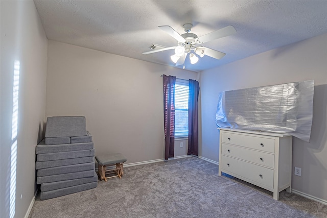 unfurnished room with ceiling fan, light colored carpet, and a textured ceiling