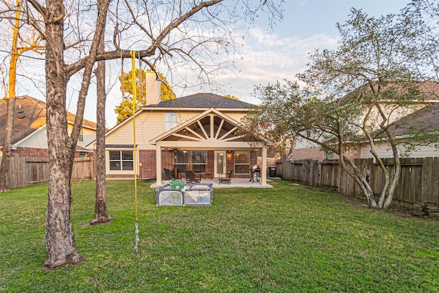 rear view of house with a lawn and a patio