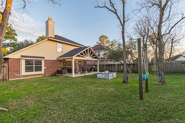 rear view of house with a lawn and a patio