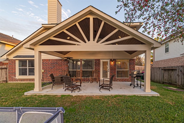 rear view of house featuring a yard, ceiling fan, and a patio