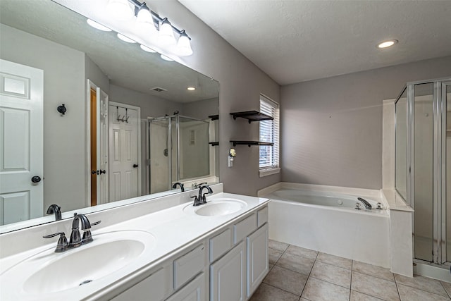 bathroom featuring vanity, separate shower and tub, a textured ceiling, and tile patterned flooring