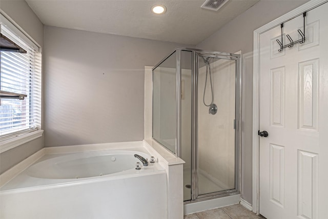 bathroom featuring a textured ceiling, independent shower and bath, and tile patterned flooring