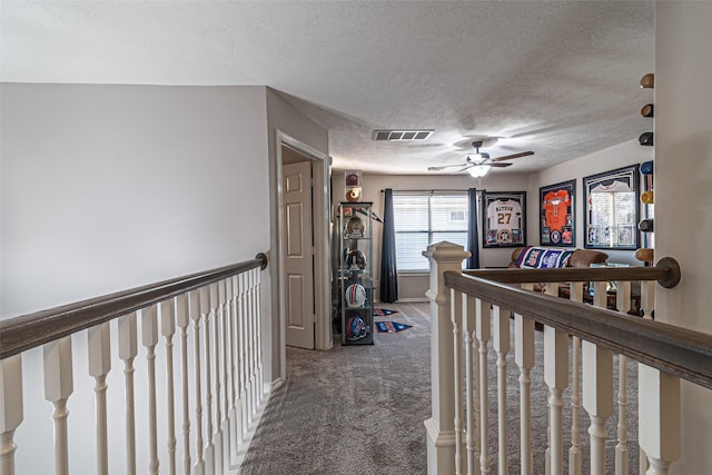 hall with carpet and a textured ceiling