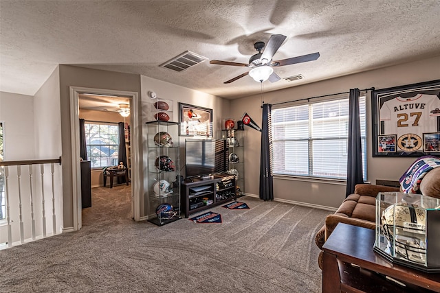 living area with carpet floors, a textured ceiling, and ceiling fan