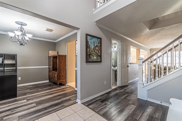 foyer entrance featuring crown molding, dark hardwood / wood-style floors, and a notable chandelier