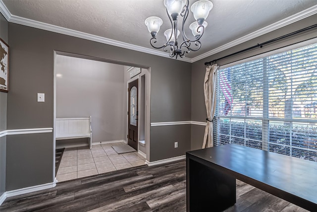 unfurnished office with hardwood / wood-style flooring, a textured ceiling, a notable chandelier, and ornamental molding