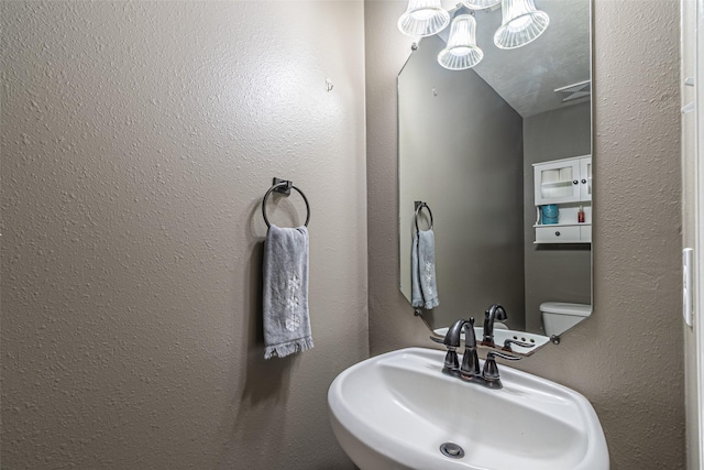 bathroom featuring sink, toilet, and a textured ceiling