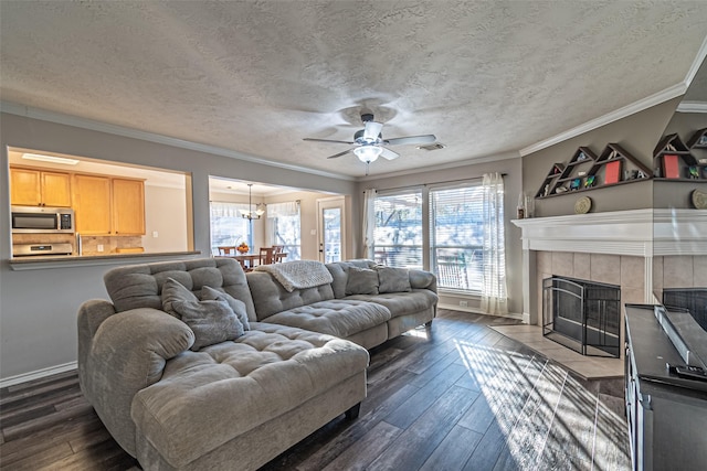 living room with dark hardwood / wood-style flooring, a textured ceiling, a tile fireplace, and ornamental molding