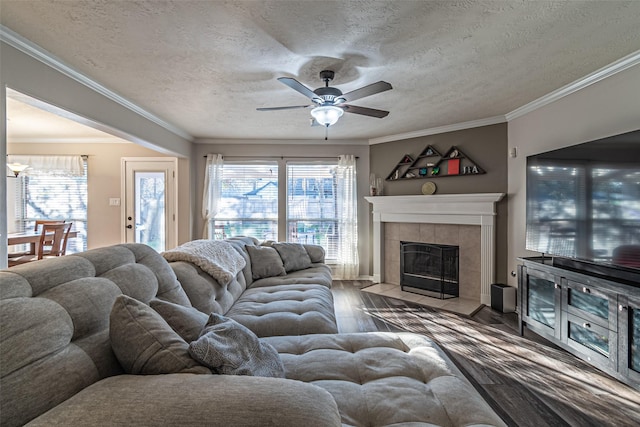 living room with a fireplace, ornamental molding, dark hardwood / wood-style floors, and a textured ceiling