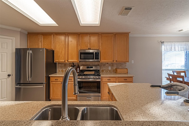 kitchen with sink, backsplash, crown molding, and appliances with stainless steel finishes