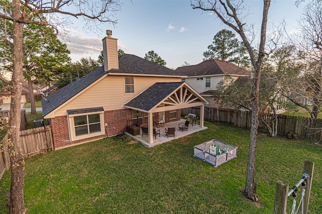 back of property featuring a lawn and a patio