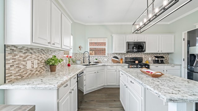 kitchen with a kitchen island, appliances with stainless steel finishes, sink, white cabinets, and ornamental molding