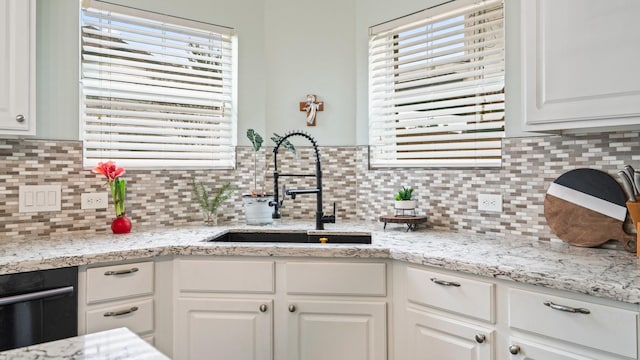 kitchen featuring white cabinetry, sink, and a wealth of natural light